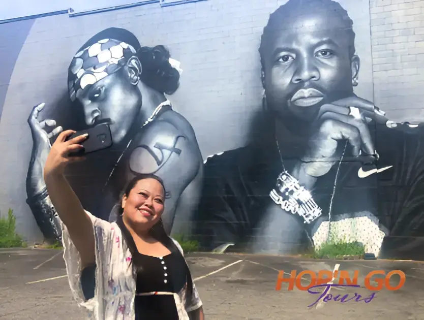 Guest taking a selfie in front of an Atlanta hip hop mural