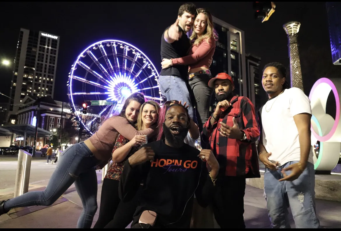 Guests celebrating by the SkyView Atlanta ferris wheel at night