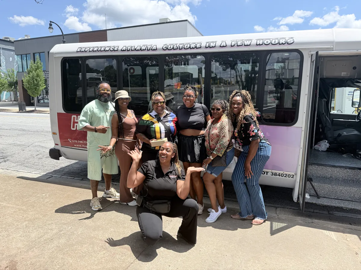 Group posing in front of the Hop'N Go bus